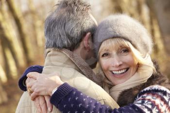 Senior couple hugging outdoors in winter