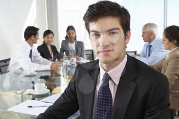 Businessman Sitting Around Boardroom Table With Colleagues