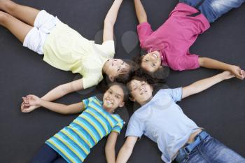 Overhead View Of Group Of Children Lying On Trampoline Together