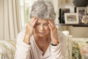 Unhappy Retired Senior Woman Sitting On Sofa At Home