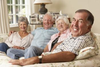 Group Of Retired Friends Sitting On Sofa At Home Together
