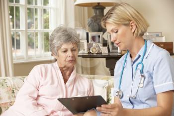 Retired Senior Woman Having Health Check With Nurse At Home