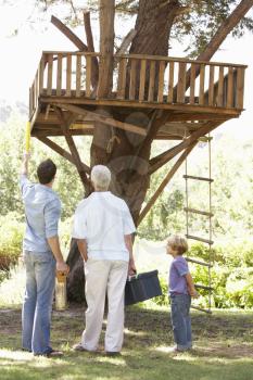 Grandfather, Father And Son Building Tree House Together