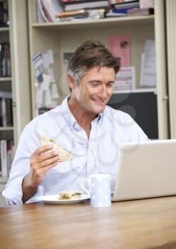 Man Having Working Lunch In Home Office