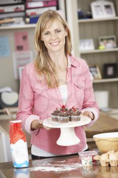 Woman With Homemade Cupcakes In Kitchen