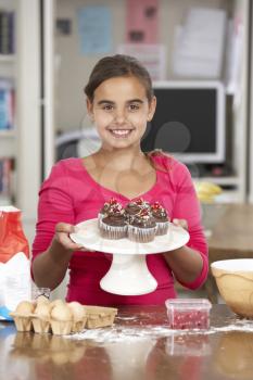 Girl With Homemade Cupcakes In Kitchen
