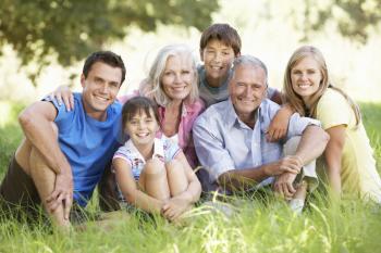 Three Generation Family Relaxing In Summer Field