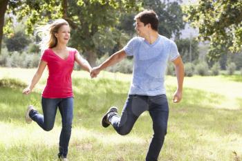 Romantic Young Couple Running Through Countryside