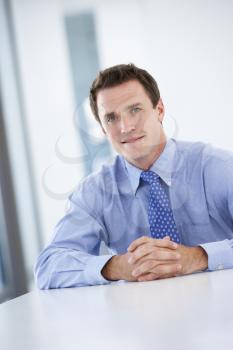 Portrait Of Male Executive Working At Desk In Office