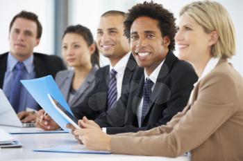 Portrait Of Male Executive Attending Office Meeting With Colleagues