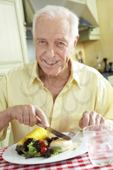 Senior Man Eating Meal In Kitchen