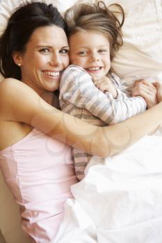 Mother And Daughter Relaxing In Bed