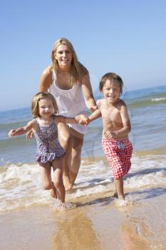 Mother Chasing Children Along Beach