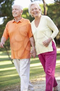 Senior Couple Walking In Park Together