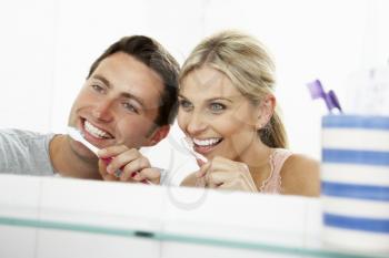 Couple In Bathroom Brushing Teeth