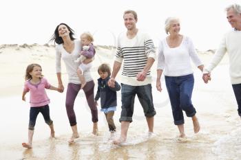 Multi Generation Family Walking Along Beach Together