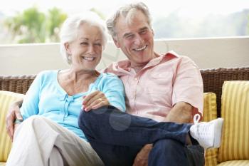 Senior Couple Sitting On Outdoor Seat Together