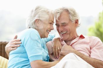 Senior Couple Sitting On Outdoor Seat Together