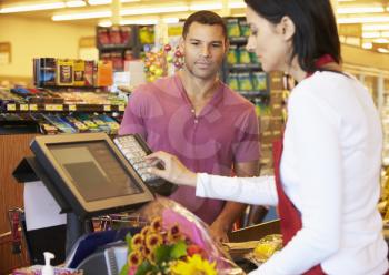 Customer Paying For Shopping At Supermarket Checkout