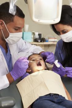 Young Girl Having Check Up At Dentists Surgery