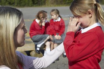 Teacher Comforting Victim Of Bullying In Playground