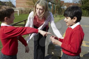 Teacher Stopping Two Boys Fighting In Playground