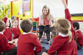 Teacher Reading Story To Elementary School Pupils