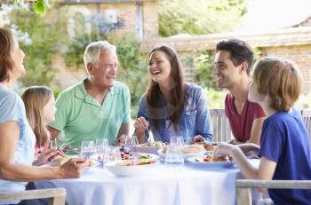 Multi Generation Family Enjoying Outdoor Meal Together