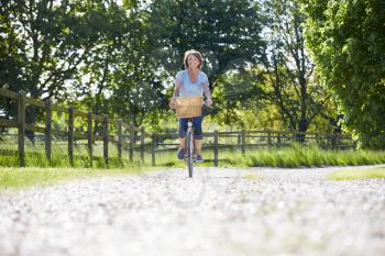 Attractive Mature Woman Riding Bike Along Country Lane