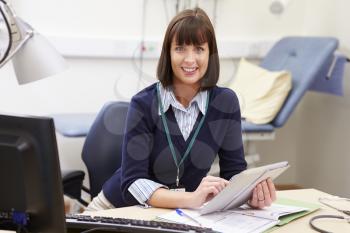Female Consultant Using Digital Tablet At Desk In Office