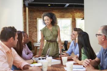 Female Boss Addressing Office Workers At Meeting