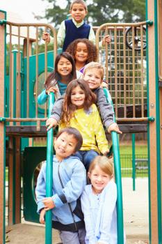 Young Children Sitting On Climbing Frame In Playground