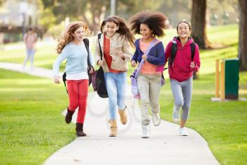 Group Of Young Girls Running Towards Camera In Park