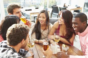 Group Of Friends Enjoying Drink At Outdoor Rooftop Bar