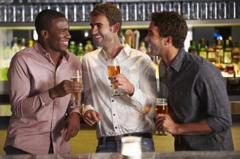 Three Male Friends Enjoying Drink At Bar