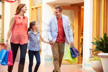 Family Walking Through Mall With Shopping Bags
