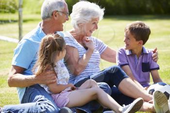 Grandparents And Grandchildren Playing Football In Garden