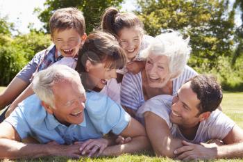 Multi Generation Family Piled Up In Garden Together