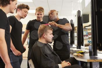 Teacher Helping Students Training To Become Hairdressers