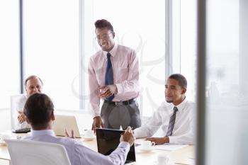 Four Businessmen Having Meeting Around Boardroom Table