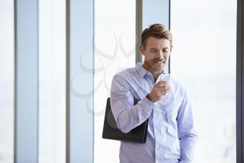 Casually Dressed Businessman Using Mobile Phone In Office