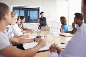 Businesswoman By Screen Addressing Boardroom Meeting