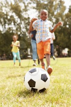 Family Playing Soccer In Park Together