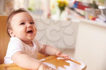 Happy Baby In High Chair At Meal Time