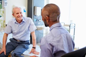 Senior Patient And Doctor Have Consultation In Hospital Room