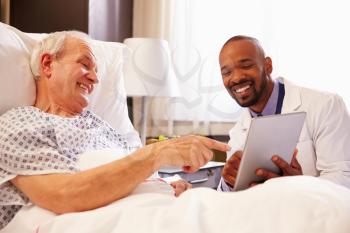 Doctor Talking To Senior Male Patient In Hospital Bed