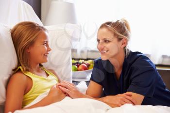 Nurse Talking To Child Patient In Hospital Bed
