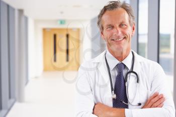 Portrait Of Male Doctor Standing In Hospital Corridor
