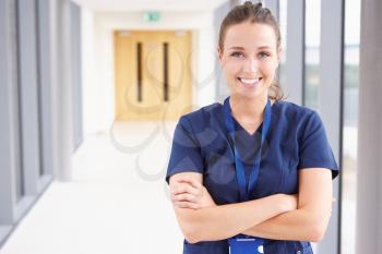 Portrait Of Female Nurse Standing In Hospital Corridor