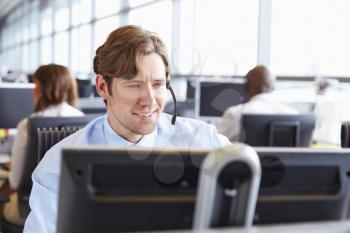 Male call centre worker, looking at screen, close-up